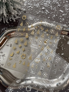 Detailed view of gold and silver Christmas tree nail stickers with embossed holiday patterns