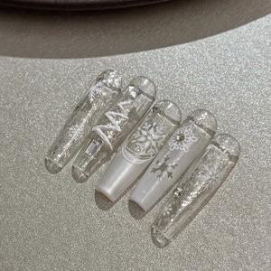 Silver Christmas snowflake press-on nails with 3D white patterns and glitter accents