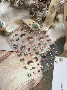 Detail showing 5D embossed Christmas nail stickers with tree and bow patterns