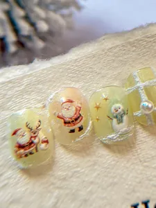 Macro shot of 3D embossed Christmas nail art with Santa, reindeer, and pearl details