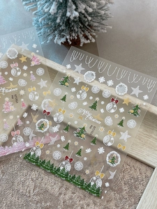 Macro shot of gold foil Christmas tree nail stickers with snowflake and star patterns