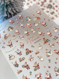 Macro detail of laser gold Christmas nail stickers with Santa Claus and snowman motifs