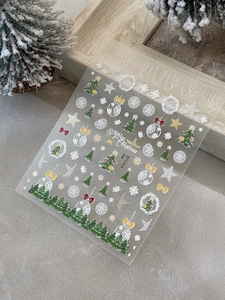 Macro view of Christmas nail stickers with gold trees and snowflakes for manicure art