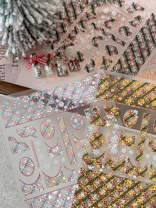 Close-up of Christmas nail stickers with red plaid patterns and snowflake embossing