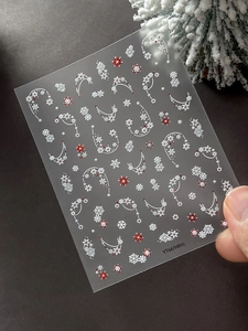 Detaillierte Weihnachts-Nagelsticker mit roten und weißen Schneeflocken und Perlenkette