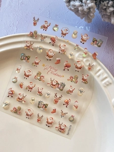 Detailed view of 3D embossed Santa Claus and reindeer nail art stickers on a ceramic plate