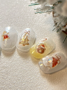 Detailed view of Christmas nail art featuring gingerbread man and 3D tree patterns