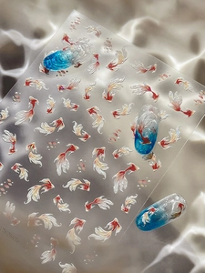 Detail of red koi fish nail art stickers with glitter edges on satin background