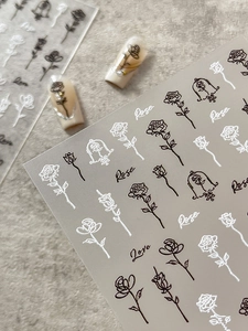 Detail view of 3D embossed rose nail stickers with black and white floral patterns