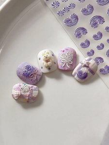 Detail of 3D jelly purple nail stickers with bear and bow charms on ceramic tray