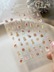 Detailed view of Christmas nail stickers featuring Santa, snowmen, and gingerbread men
