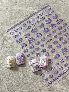 Close-up of 5D embossed purple swirl nail stickers with 3D bunny and heart nail art