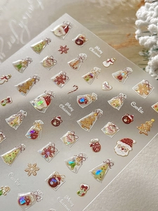 Macro shot of 3D Christmas nail stickers with Santa, tree and gingerbread cookie motifs