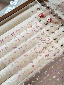 Close-up of 3D relief bow nail stickers in pastel colors for DIY manicure art
