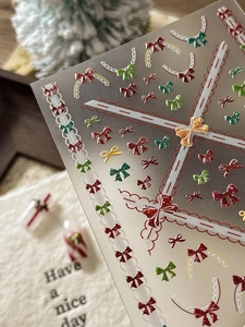 Détail macro de stickers ongles 3D avec nœuds de Noël et dentelle aux motifs festifs