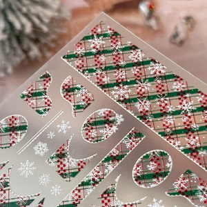 Embossed Christmas nail stickers with red green plaid patterns and white snowflake motifs