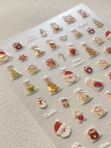 Close-up of 5D embossed Christmas nail stickers with Santa, snowman and cookie patterns