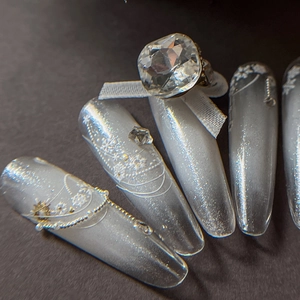 Silberne Katzenaugen-Nägel zum Aufdrücken mit Spitzenmustern, Perlen und großen Diamanten