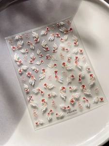 Close-up of 3D embossed koi fish nail art stickers with elegant red and gold detailing
