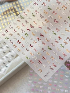 Macro detail of embossed bow nail stickers in various colors with 3D texture YT6235