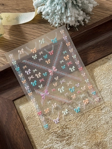 Détail de stickers 3D pour ongles avec nœuds colorés et motifs de dentelle délicats