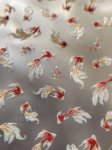 Macro view of 3D embossed koi fish nail stickers with shimmering pearl texture