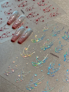 Detailed holographic star and moon nail stickers applied on elegant long gradient nails
