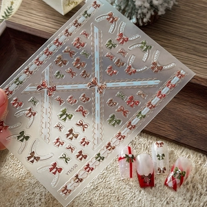 Stickers à ongles 3D de Noël avec nœuds rouges et dorés pour manucure de fête élégante