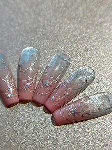 Macro detail of long ballerina nails with pink gradient cat-eye effect and silver stars