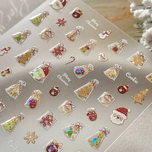 Christmas nail stickers with Santa, tree, and cookie patterns in red, green and gold