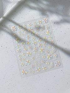 Macro detail of laser iridescent floral nail art stickers with pearlescent shell finish
