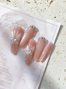 Detailed macro view of pink cat eye nail stickers with 3D white butterfly and rhinestones