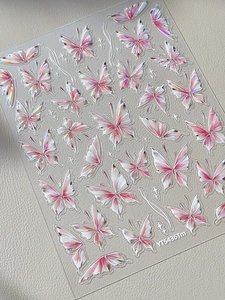 Macro view of 3D holographic butterfly nail art stickers with pink gradient and relief texture