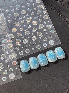 Détail de stickers à ongles 3D avec finition laser irisante et motifs de cœur et d'étoile