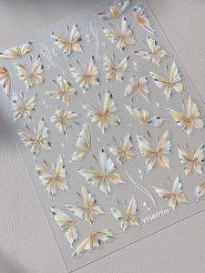 Macro detail of holographic butterfly nail stickers with pearlescent finish and star accents