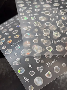 Vue macro détaillée de stickers ongles holographiques laser avec bulles et étoiles