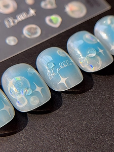 Détail de gouttes d'eau 3D sur ongles dégradé bleu clair avec inscription Bubbles