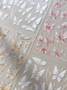 Detail showing 3D holographic butterfly nail art stickers in pink and white tones