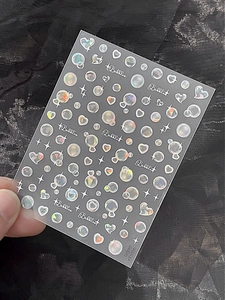 Vue macro d'autocollants 3D holographiques pour ongles avec cœurs et étoiles