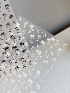 Macro detail of 3D embossed summer nail stickers with black and white coconut tree patterns