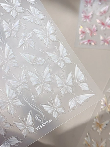 Close-up of translucent butterfly nail stickers with pearlescent laser finish and sharp details