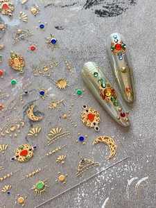 Detail of gold baroque nail stickers with colorful gems and 3D celestial elements