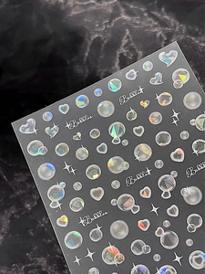 Détail d'autocollants holographiques pour ongles avec éclat métallique et motifs de bulles