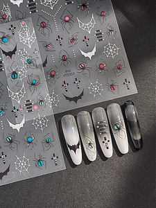 Detail of gothic spider web and bat nail stickers with 3D metallic effect on nails