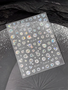 Détail macro d'autocollants holographiques pour ongles avec bulles et motifs étoilés