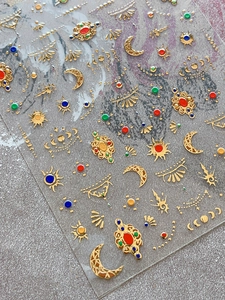Detailed view of 3D gold embossed nail stickers with bohemian moon and sun patterns