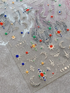 Macro view of bohemian nail art stickers featuring sun moon motifs and colorful gems