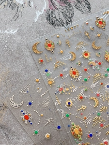 Detail of baroque nail art stickers with gold foil stars, moon, and gemstone designs