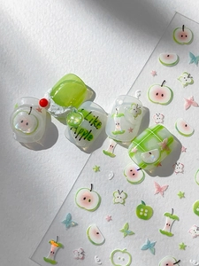 Detailed view of green apple nail stickers and 3D butterfly press-on nails set