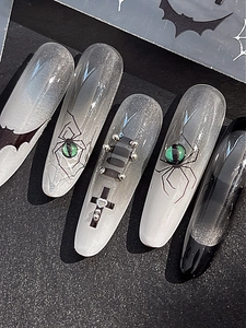 Macro shot of gothic Halloween nails with silver glitter, 3D spiders and bat patterns
